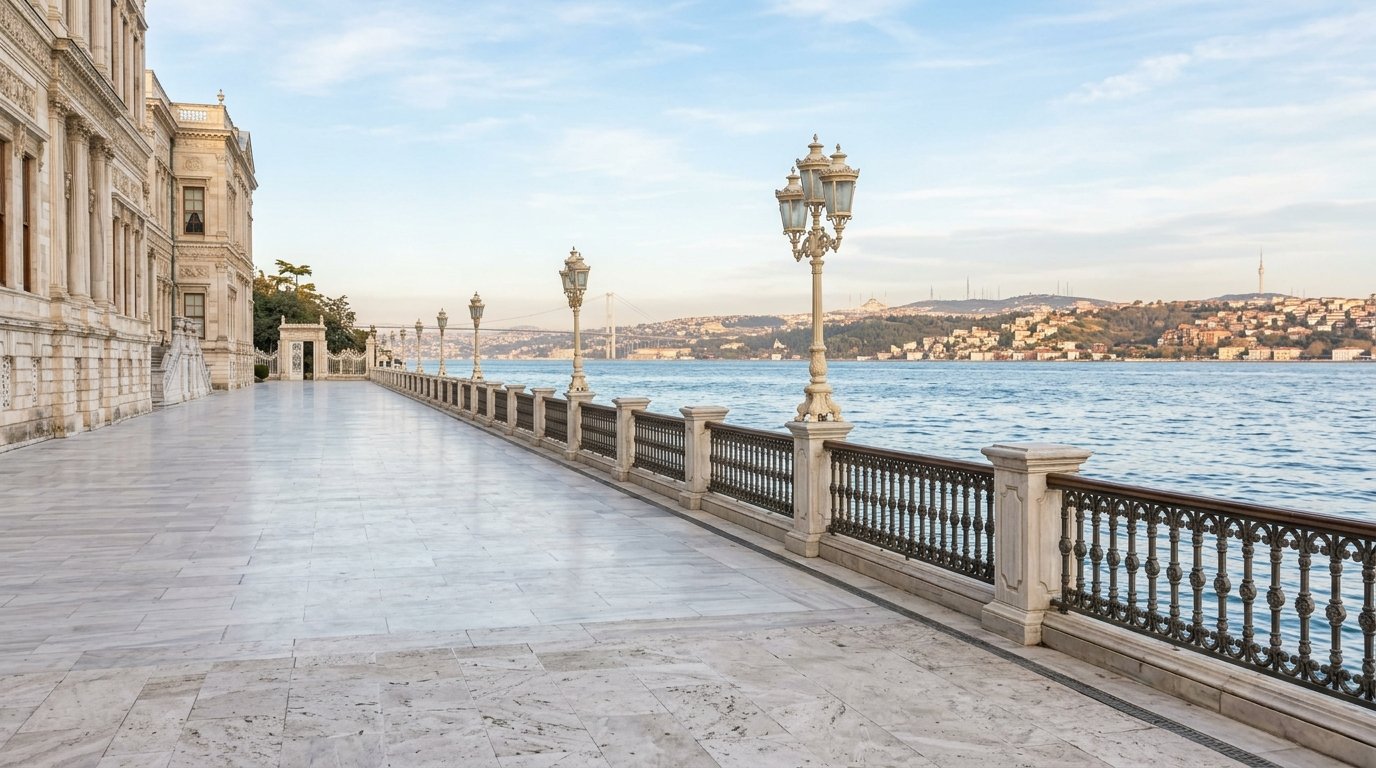 The marble waterfront terrace of Dolmabahce Palace in morning light, with the Bosphorus beyond the railings